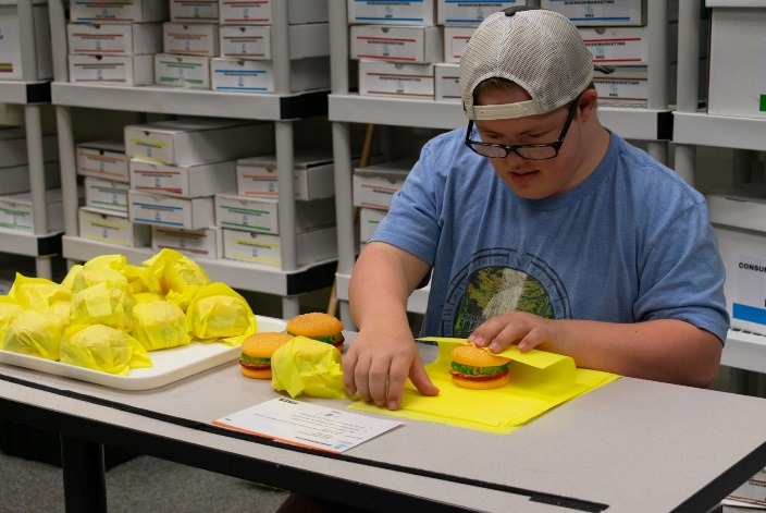 A person sitting at a table with foodDescription automatically generated